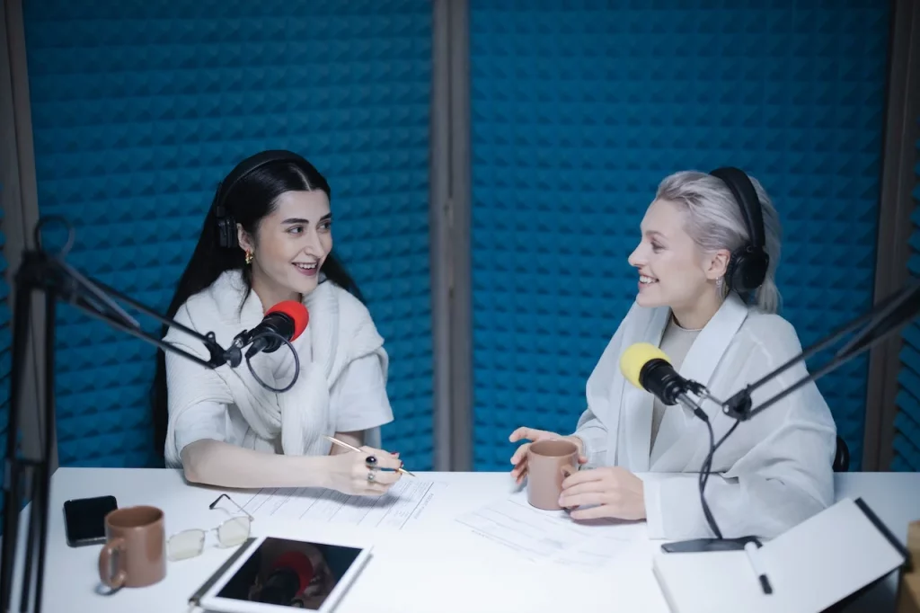 Two female podcasts recording in a studio